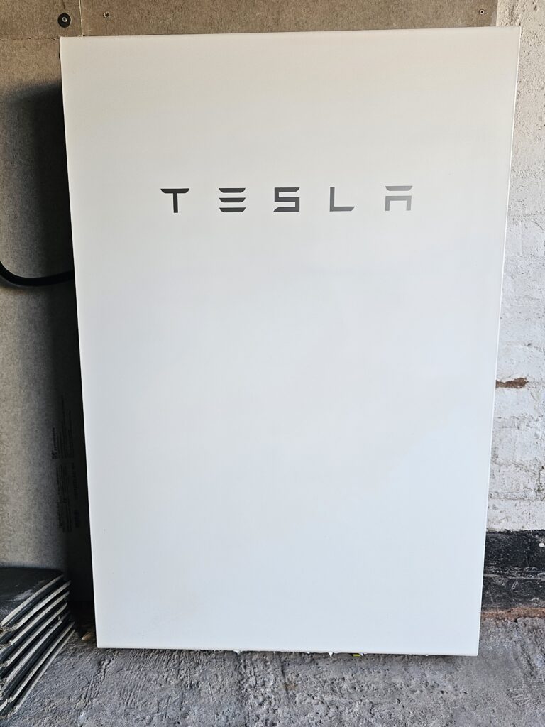 Tesla Powerwall battery fixed to a wall