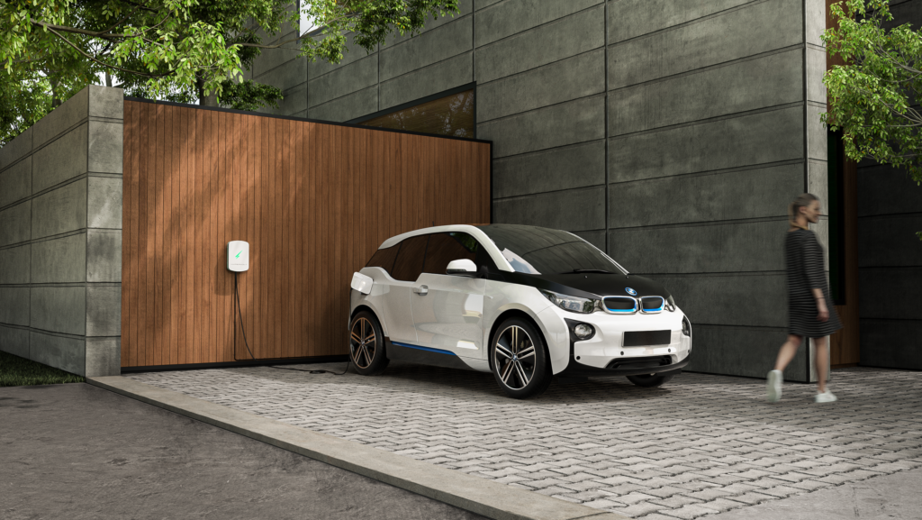 BMW plugged into an EV charger next to a modern home