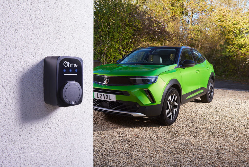 OHME Epod fixed on wall of house with a green Vauxhall mokka on driveway